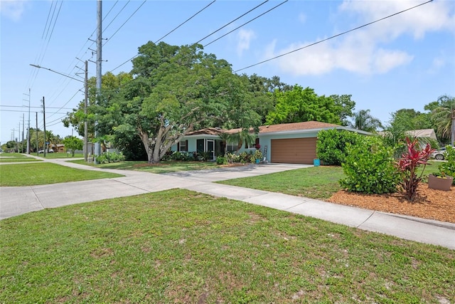1711 N Highland Ave, Clearwater, FL 33755 - view of property hidden behind natural elements with concrete driveway, a front yard, and an attached garage