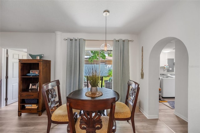 1711 N Highland Ave, Clearwater, FL 33755 - dining room with washer / dryer, arched walkways, light wood-style floors, and electric panel