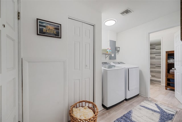 1711 N Highland Ave, Clearwater, FL 33755 - washroom featuring washing machine and dryer, electric panel, and light wood-style floors
