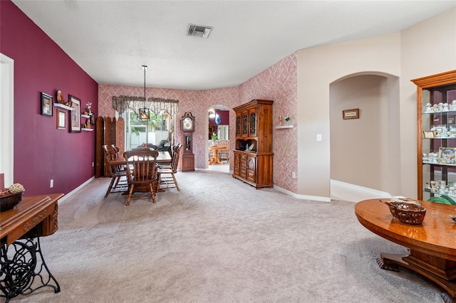 3246 Brenford Pl, Land O Lakes, FL 34638 - carpeted dining room featuring arched walkways, an accent wall, a chandelier, and wallpapered walls