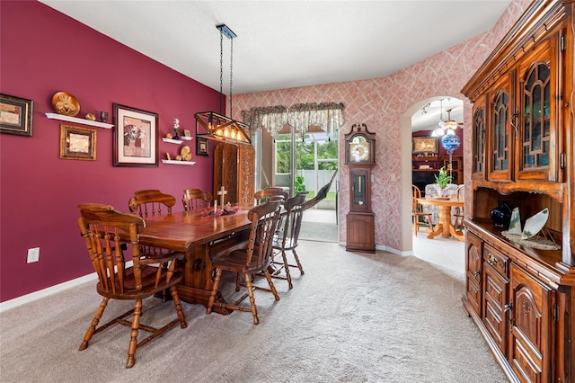 3246 Brenford Pl, Land O Lakes, FL 34638 - dining area featuring arched walkways, light colored carpet, wallpapered walls, a chandelier, and an accent wall