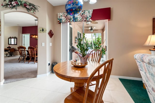 3246 Brenford Pl, Land O Lakes, FL 34638 - dining space featuring light colored carpet, light tile patterned flooring, arched walkways, a ceiling fan, and a chandelier
