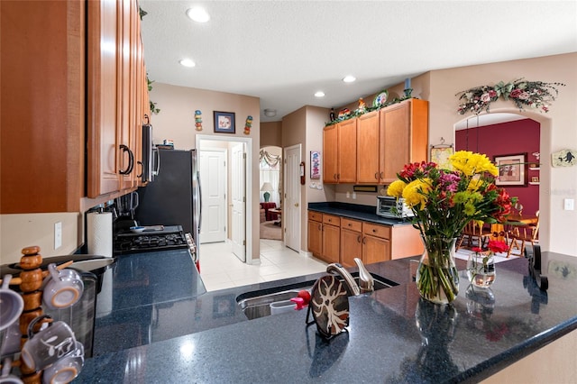 3246 Brenford Pl, Land O Lakes, FL 34638 - kitchen featuring brown cabinets, recessed lighting, dark countertops, a peninsula, and a textured ceiling