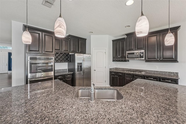 6706 Riverside Bluffs Dr, Riverview, FL 33578 - kitchen featuring appliances with stainless steel finishes, dark stone counters, a textured ceiling, pendant lighting, and recessed lighting