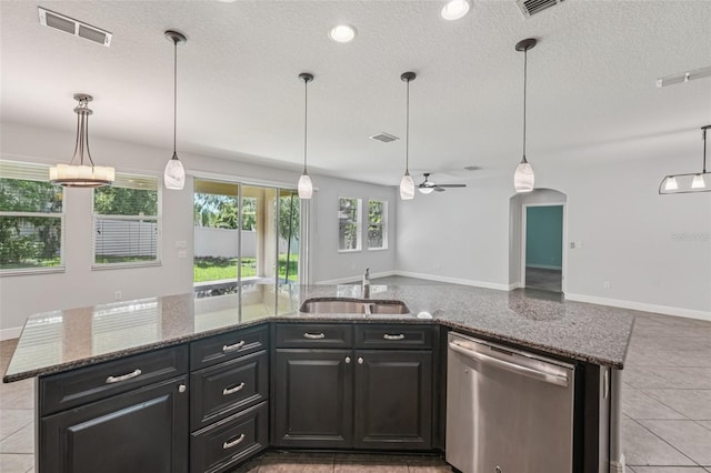 6706 Riverside Bluffs Dr, Riverview, FL 33578 - kitchen featuring stainless steel dishwasher, open floor plan, stone counters, light tile patterned floors, and a textured ceiling