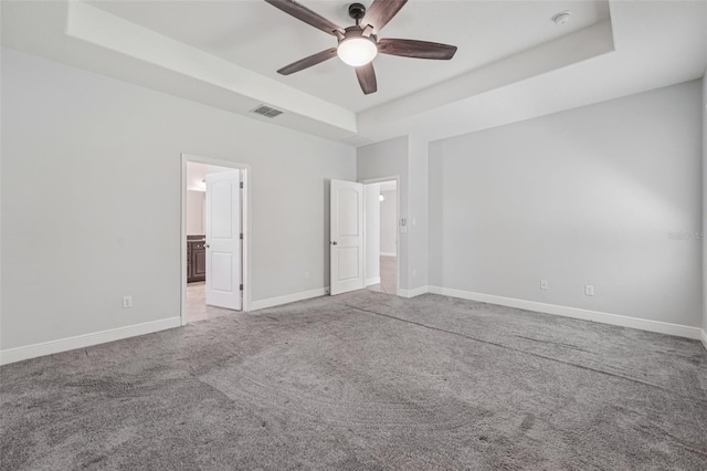 6706 Riverside Bluffs Dr, Riverview, FL 33578 - unfurnished bedroom with a tray ceiling, carpet floors, a ceiling fan, and ensuite bath