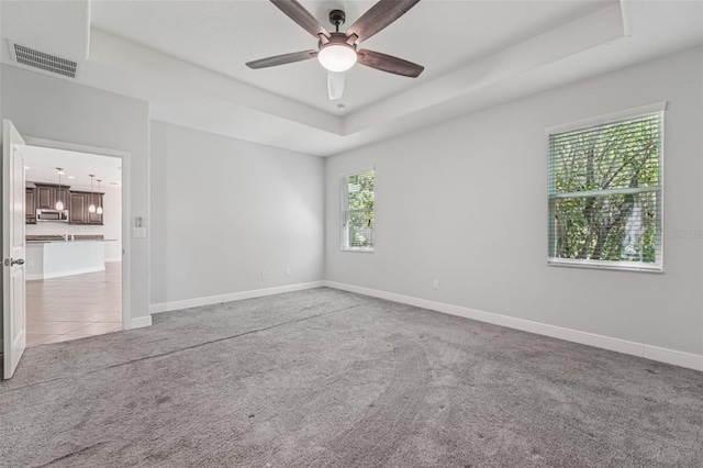 6706 Riverside Bluffs Dr, Riverview, FL 33578 - unfurnished room featuring light colored carpet, a ceiling fan, and a raised ceiling