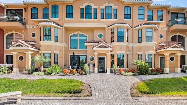 2741 Via Cipriani Unit 916A, Clearwater, FL 33764 - view of front facade featuring stucco siding, a balcony, curved driveway, and a tiled roof