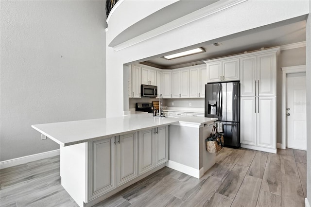 2741 Via Cipriani Unit 916A, Clearwater, FL 33764 - kitchen with appliances with stainless steel finishes, light countertops, light wood-style floors, and white cabinetry