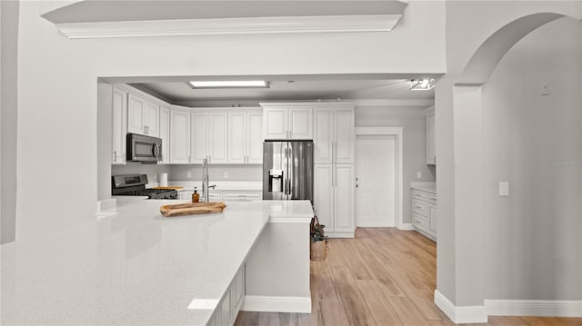 2741 Via Cipriani Unit 916A, Clearwater, FL 33764 - kitchen with appliances with stainless steel finishes, light wood finished floors, light countertops, white cabinetry, and ornamental molding