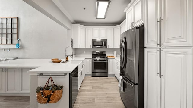 2741 Via Cipriani Unit 916A, Clearwater, FL 33764 - kitchen with appliances with stainless steel finishes, a peninsula, light countertops, white cabinetry, and crown molding