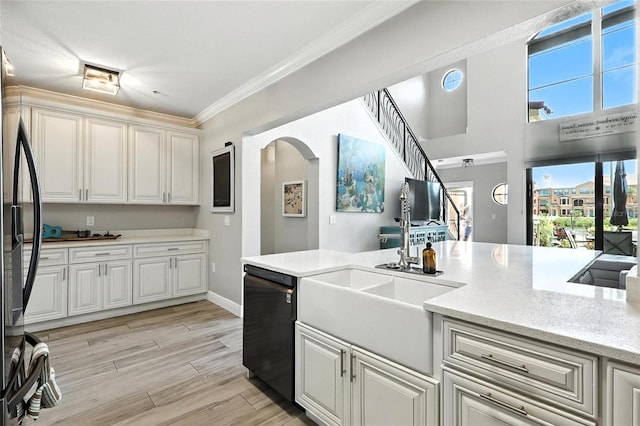 2741 Via Cipriani Unit 916A, Clearwater, FL 33764 - kitchen with dishwashing machine, freestanding refrigerator, crown molding, light wood finished floors, and arched walkways