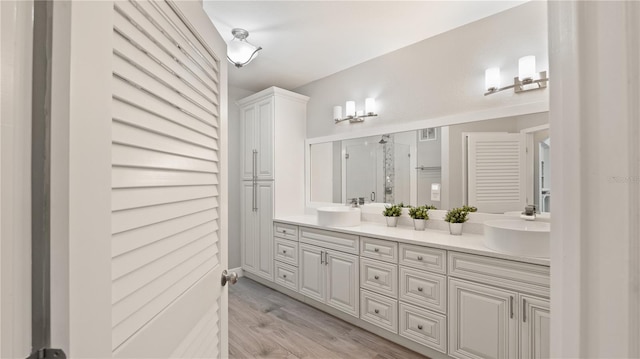 2741 Via Cipriani Unit 916A, Clearwater, FL 33764 - full bath featuring double vanity, a shower stall, and wood finished floors