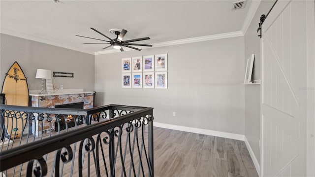 2741 Via Cipriani Unit 916A, Clearwater, FL 33764 - bedroom with wood finished floors, ornamental molding, a ceiling fan, and a barn door