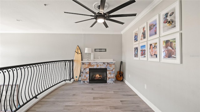 2741 Via Cipriani Unit 916A, Clearwater, FL 33764 - living area with ornamental molding, a ceiling fan, wood finished floors, and a stone fireplace