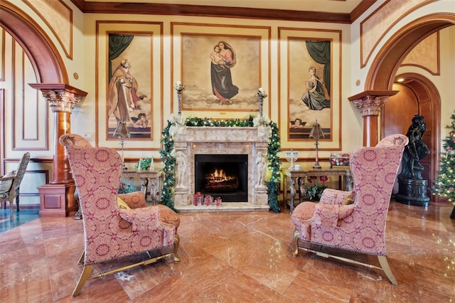 2741 Via Cipriani Unit 916A, Clearwater, FL 33764 - sitting room with crown molding, marble tiled flooring, a fireplace, a decorative wall, and arched walkways