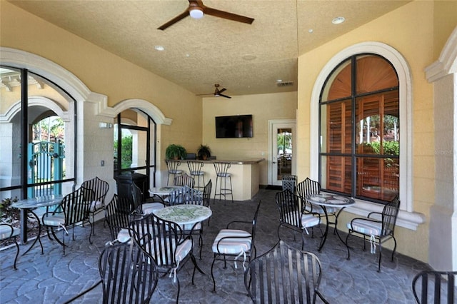 2741 Via Cipriani Unit 916A, Clearwater, FL 33764 - view of patio / terrace featuring a ceiling fan and a bar