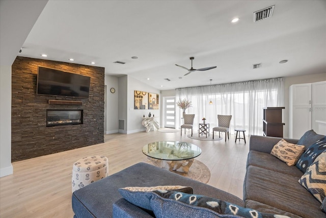 3956 Versailles Dr, Tampa, FL 33634 - living area featuring light wood-type flooring, a ceiling fan, a stone fireplace, vaulted ceiling, and recessed lighting