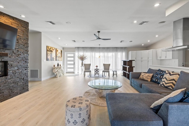 3956 Versailles Dr, Tampa, FL 33634 - living room featuring ceiling fan, light wood-style flooring, recessed lighting, and a stone fireplace