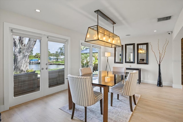 3956 Versailles Dr, Tampa, FL 33634 - dining area featuring french doors, a water view, light wood finished floors, and recessed lighting