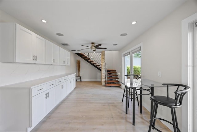 3956 Versailles Dr, Tampa, FL 33634 - dining room with stairs, light wood-style floors, a ceiling fan, and recessed lighting