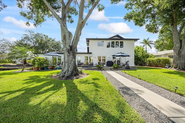 3956 Versailles Dr, Tampa, FL 33634 - traditional-style home with stucco siding, a front yard, a patio area, and french doors