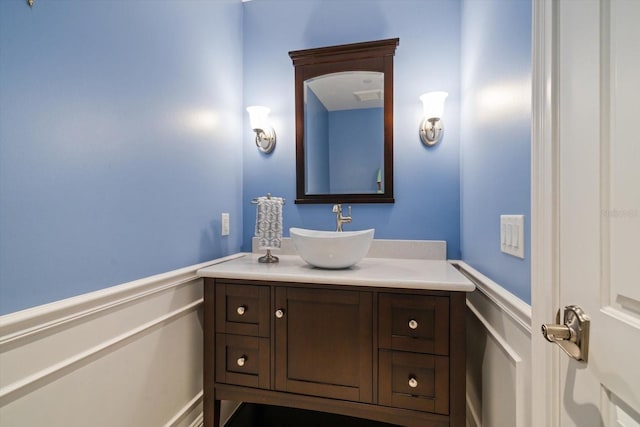 125 Belleview Blvd Unit 503, Belleair, FL 33756 - bathroom featuring vanity, wainscoting, and a decorative wall