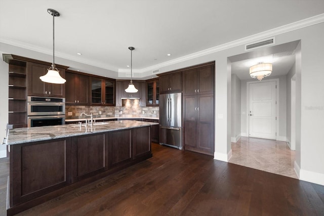 125 Belleview Blvd Unit 503, Belleair, FL 33756 - kitchen with stainless steel appliances, dark brown cabinetry, decorative backsplash, glass insert cabinets, and dark wood-type flooring