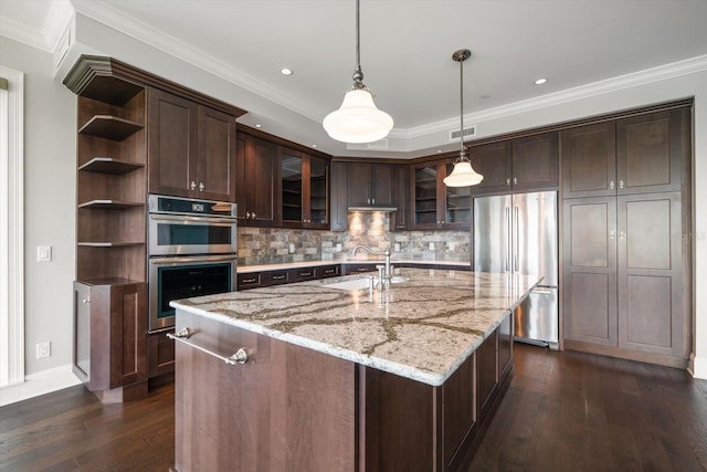 125 Belleview Blvd Unit 503, Belleair, FL 33756 - kitchen with appliances with stainless steel finishes, open shelves, dark brown cabinets, dark wood finished floors, and a kitchen island with sink