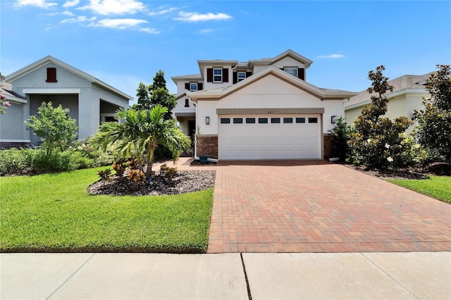 5611 Del Coronado Dr, Apollo Beach, FL 33572 - view of front of property with a front yard, decorative driveway, stucco siding, and an attached garage
