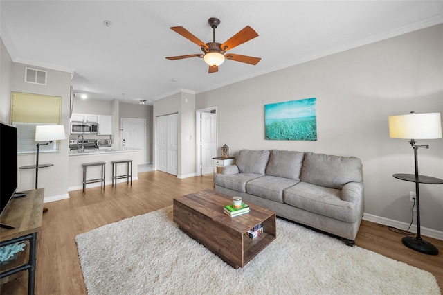 5000 Culbreath Key Way Unit 1-112, Tampa, FL 33611 - living area featuring light wood-style floors, ceiling fan, and crown molding