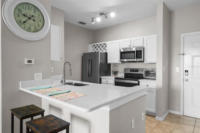 5000 Culbreath Key Way Unit 1-112, Tampa, FL 33611 - kitchen featuring stainless steel appliances, a peninsula, light tile patterned floors, a kitchen bar, and light countertops