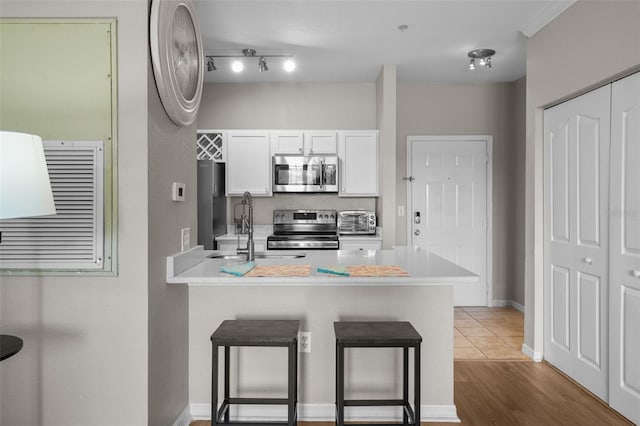 5000 Culbreath Key Way Unit 1-112, Tampa, FL 33611 - kitchen featuring stainless steel appliances, a breakfast bar, a peninsula, white cabinetry, and light countertops