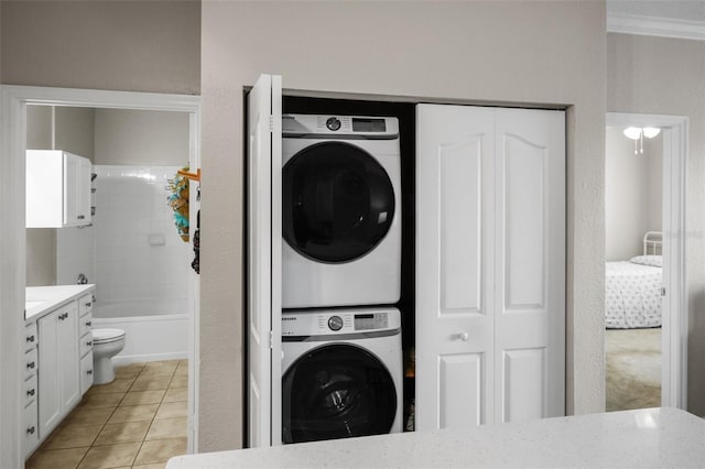 5000 Culbreath Key Way Unit 1-112, Tampa, FL 33611 - washroom with stacked washer / dryer and light tile patterned flooring