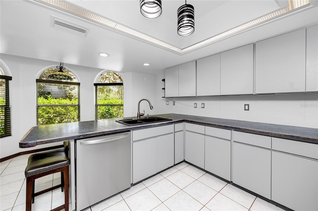 11203 Egret Nest Ct, Riverview, FL 33569 - kitchen featuring dishwasher, a peninsula, dark countertops, light tile patterned floors, and recessed lighting
