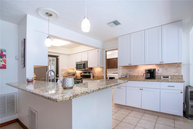 4205 Helene Pl, Valrico, FL 33594 - kitchen with stainless steel appliances, backsplash, a peninsula, white cabinetry, and light stone counters