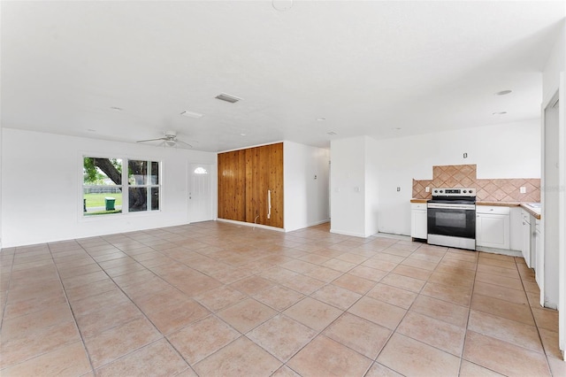 1041 SE Spinnaker Ave, Saint Lucie West, FL 34983 - unfurnished living room with ceiling fan, light tile patterned floors, and wood walls