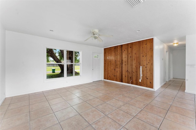 1041 SE Spinnaker Ave, Saint Lucie West, FL 34983 - spare room featuring a ceiling fan, light tile patterned floors, and wooden walls