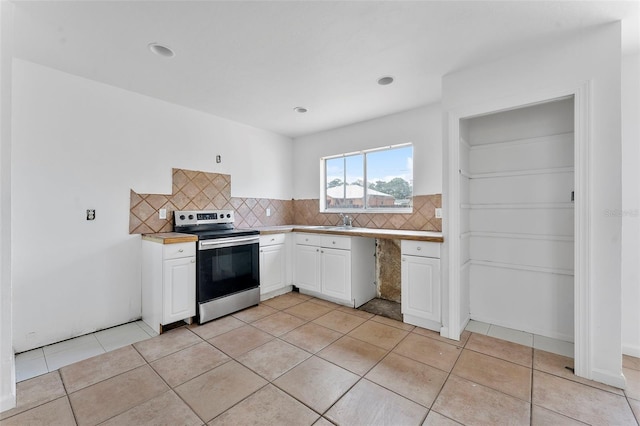 1041 SE Spinnaker Ave, Saint Lucie West, FL 34983 - kitchen with electric range, white cabinetry, backsplash, light tile patterned floors, and light countertops