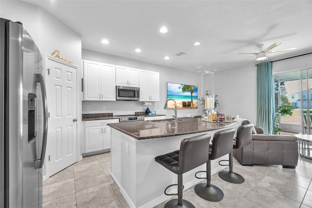 7124 Summer Holly Pl, Riverview, FL 33578 - kitchen with appliances with stainless steel finishes, a breakfast bar area, recessed lighting, white cabinets, and ceiling fan