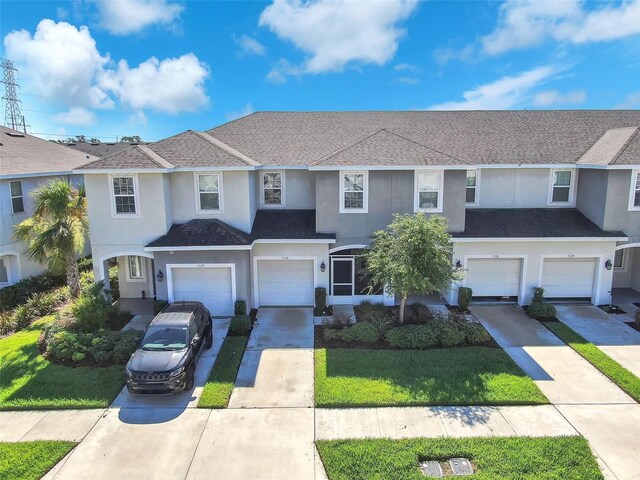 7124 Summer Holly Pl, Riverview, FL 33578 - view of front facade featuring an attached garage, stucco siding, driveway, a front lawn, and a shingled roof
