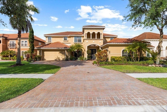 8358 Dunham Station Dr, Tampa, FL 33647 - mediterranean / spanish house with stucco siding, an attached garage, driveway, and a tiled roof
