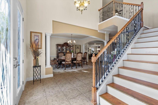 8358 Dunham Station Dr, Tampa, FL 33647 - tiled foyer entrance featuring a chandelier, a high ceiling, arched walkways, stairway, and decorative columns
