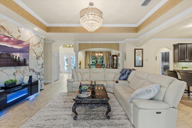 8358 Dunham Station Dr, Tampa, FL 33647 - living area with a chandelier, washer / clothes dryer, a raised ceiling, arched walkways, and crown molding