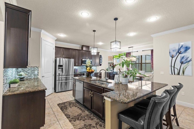 8358 Dunham Station Dr, Tampa, FL 33647 - kitchen featuring stainless steel appliances, ornamental molding, decorative backsplash, dark brown cabinetry, and a textured ceiling