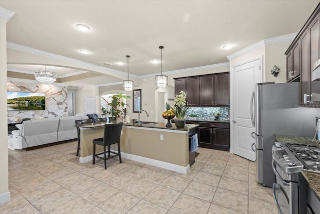 8358 Dunham Station Dr, Tampa, FL 33647 - kitchen featuring open floor plan, stainless steel gas range oven, dark brown cabinets, tasteful backsplash, and dark stone counters