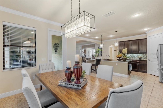 8358 Dunham Station Dr, Tampa, FL 33647 - dining area with arched walkways, light tile patterned flooring, crown molding, recessed lighting, and a chandelier