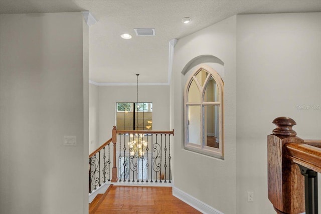 8358 Dunham Station Dr, Tampa, FL 33647 - hall with a chandelier, wood finished floors, an upstairs landing, ornamental molding, and recessed lighting