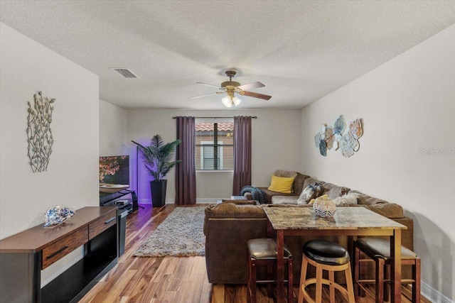 8358 Dunham Station Dr, Tampa, FL 33647 - living area featuring wood finished floors, a ceiling fan, and a textured ceiling