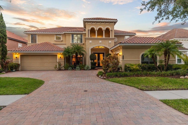 8358 Dunham Station Dr, Tampa, FL 33647 - mediterranean / spanish-style house with stucco siding, a garage, french doors, decorative driveway, and a tiled roof